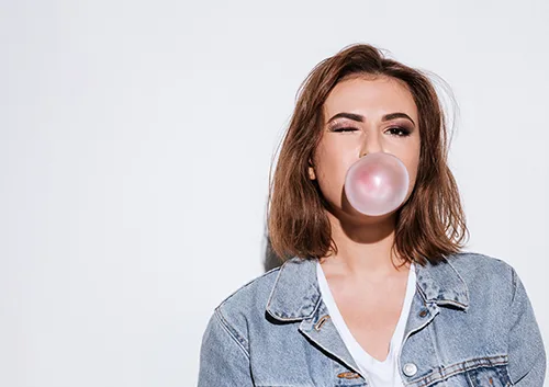 Playful lady blowing bubble with chewing gum.
