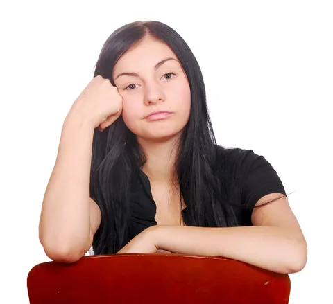Woman with long dark hair resting chin on hand, appearing thoughtful against white background.