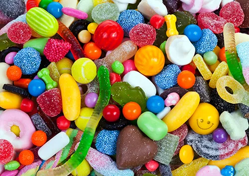 Colorful assorted candies and sweets including gummies, hard candies, and chocolate pieces.